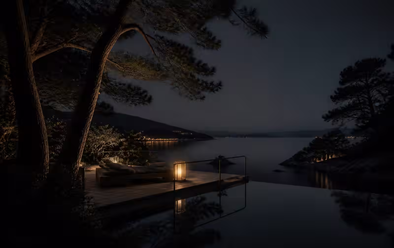 An understated resort terrace at night among pine trees beside still dark water with one lantern