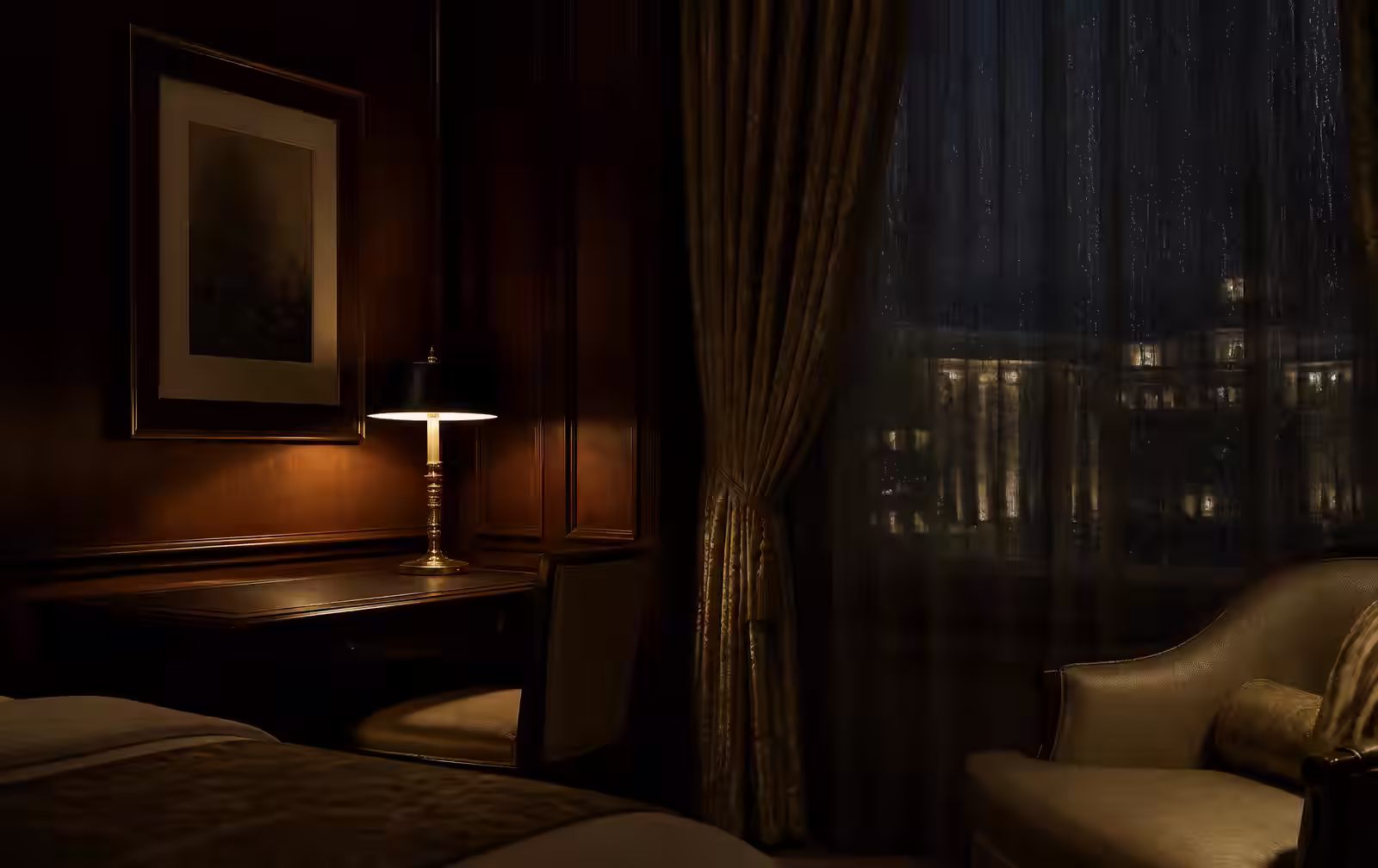 A dark panelled hotel room at night with a single lit lamp, heavy curtains and a rain-streaked window over distant lights