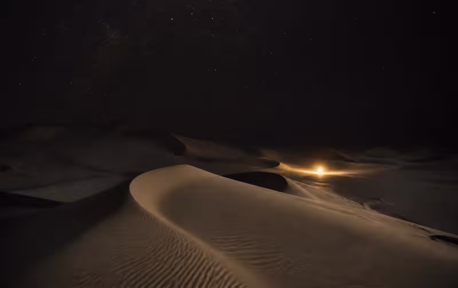 Vast empty desert dunes at night under a star-filled sky with a single distant warm gold light