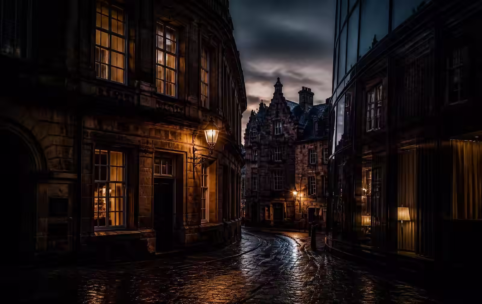 A historic stone street in Luxembourg City at dusk with warm lit windows beside a modern glass facade on wet cobbles