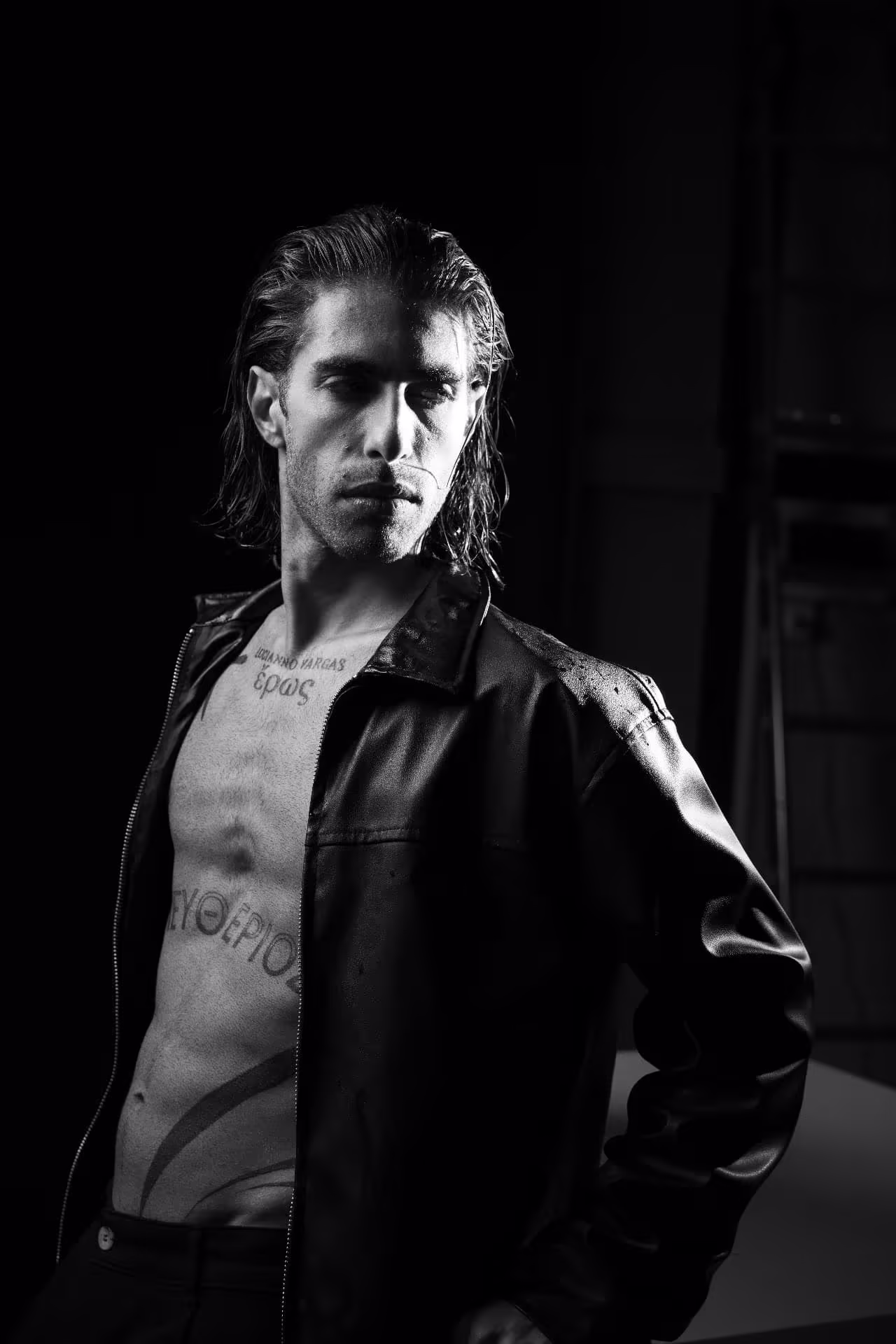 Black-and-white portrait of Lucianno Vargas in an open leather jacket