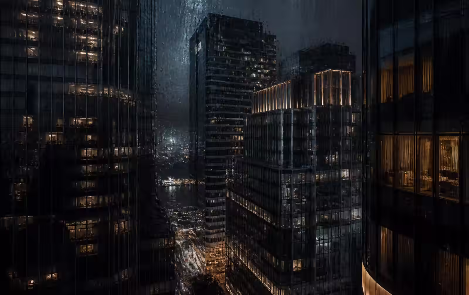 Tall dark glass towers at night seen through a rain-flecked high window, cool blue facades with scattered warm gold rooms
