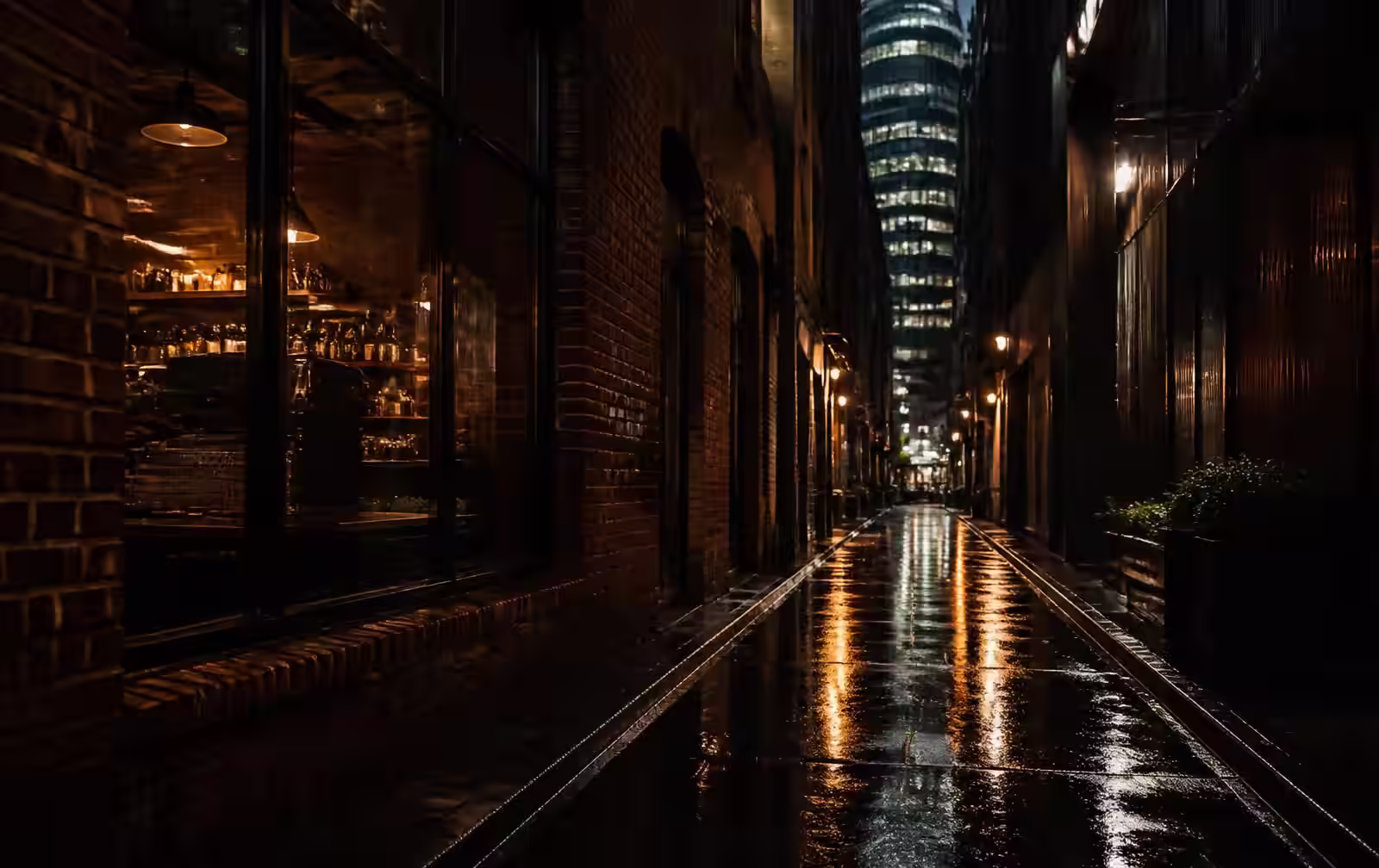 A rain-soaked Melbourne laneway at night with dark brick, wet bluestone and warm gold light from a bar window
