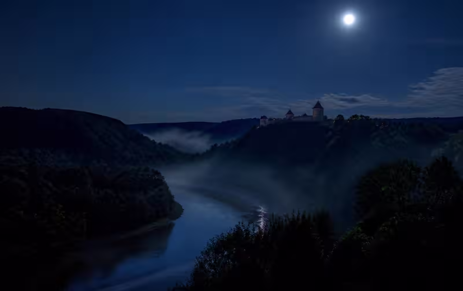 The Gauja river valley at night — mist over dark forest, a moonlit castle silhouette on a distant ridge