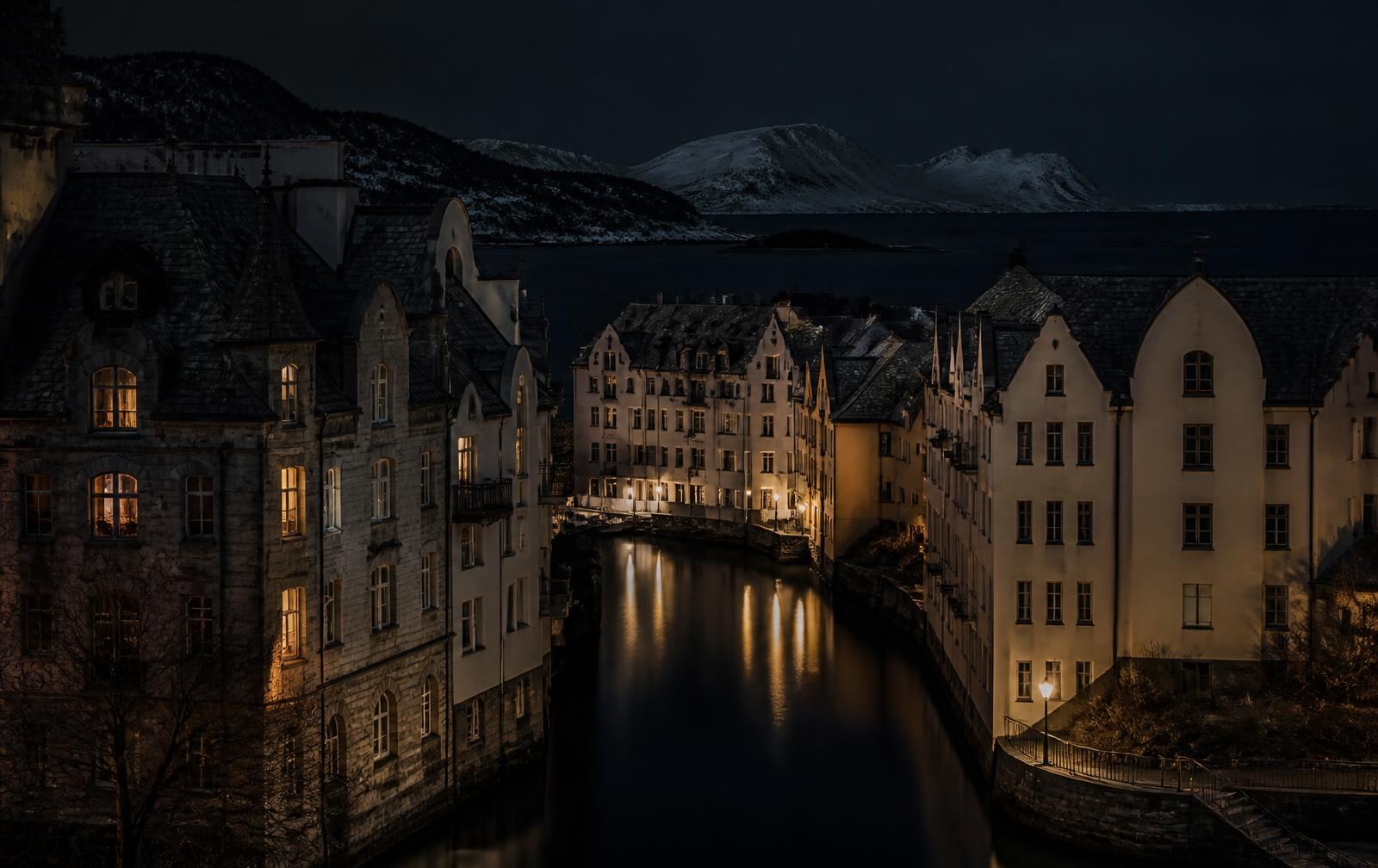 A Norwegian coastal town at night, stone art-nouveau buildings above a narrow dark canal, warm lamplight, snow-dusted islands beyond