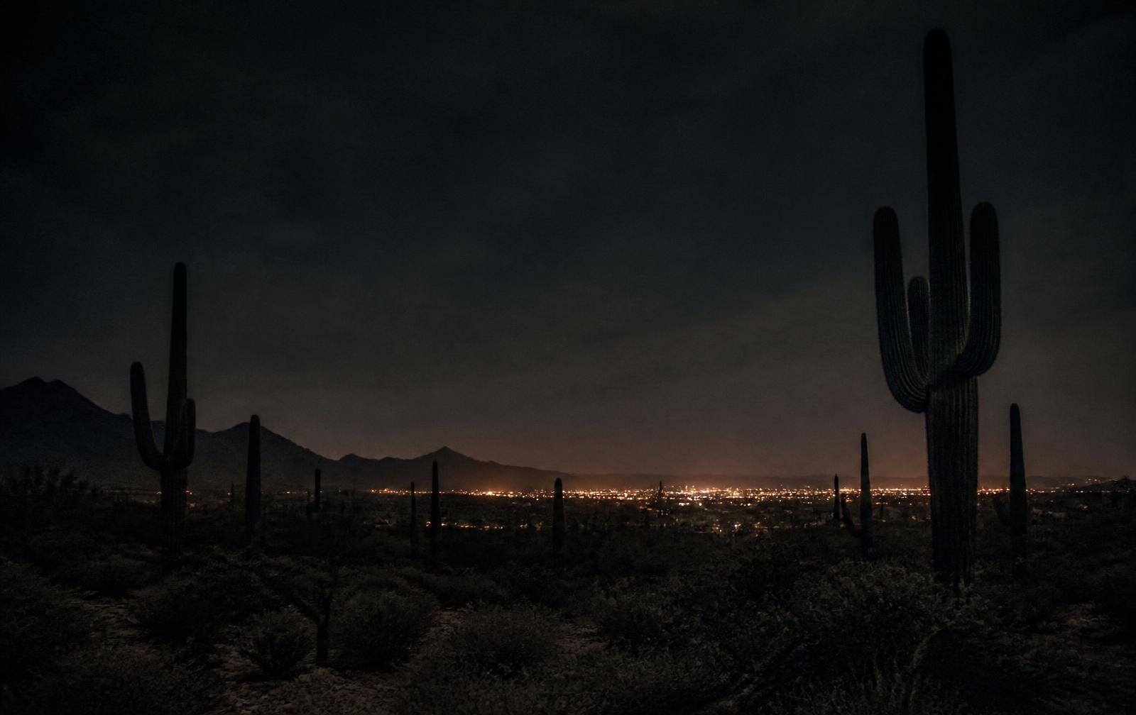 Desert mountains glowing warm orange at sunset above a quiet Arizona valley