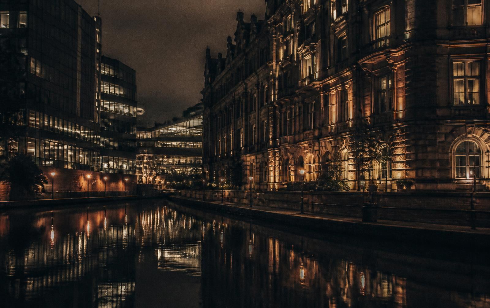 Birmingham canal at night with Victorian stone facade and modern glass reflected in dark water