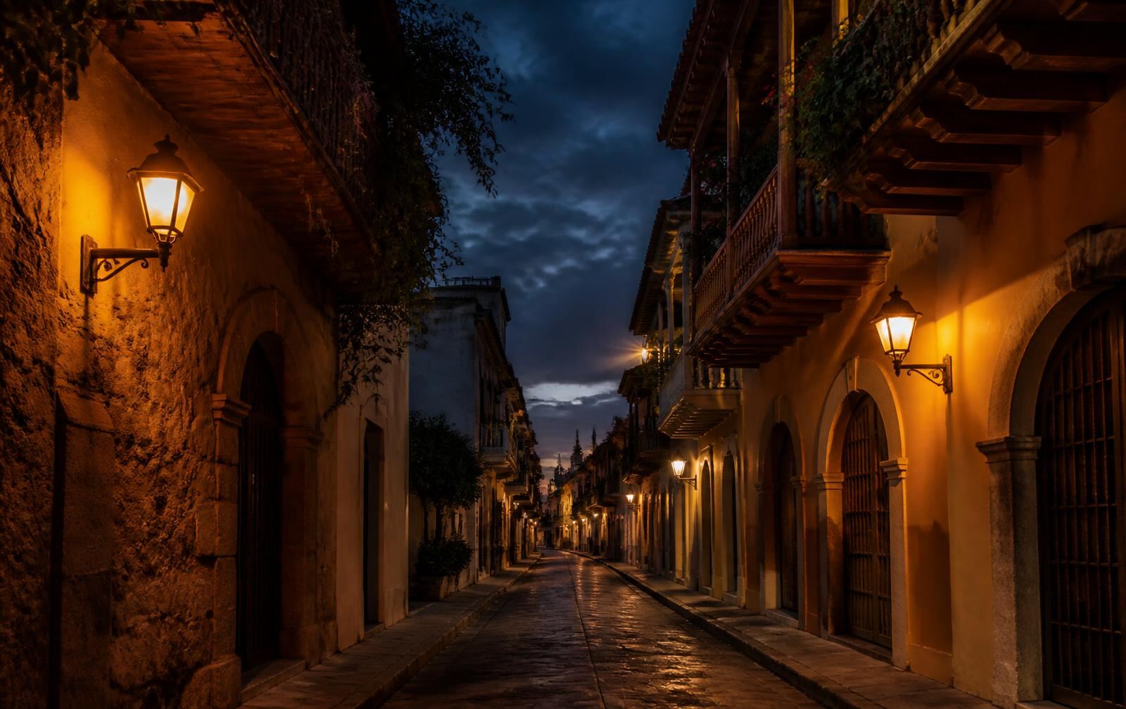 Cartagena old town street at dusk, colonial balconies and warm lantern light over a quiet cobbled lane