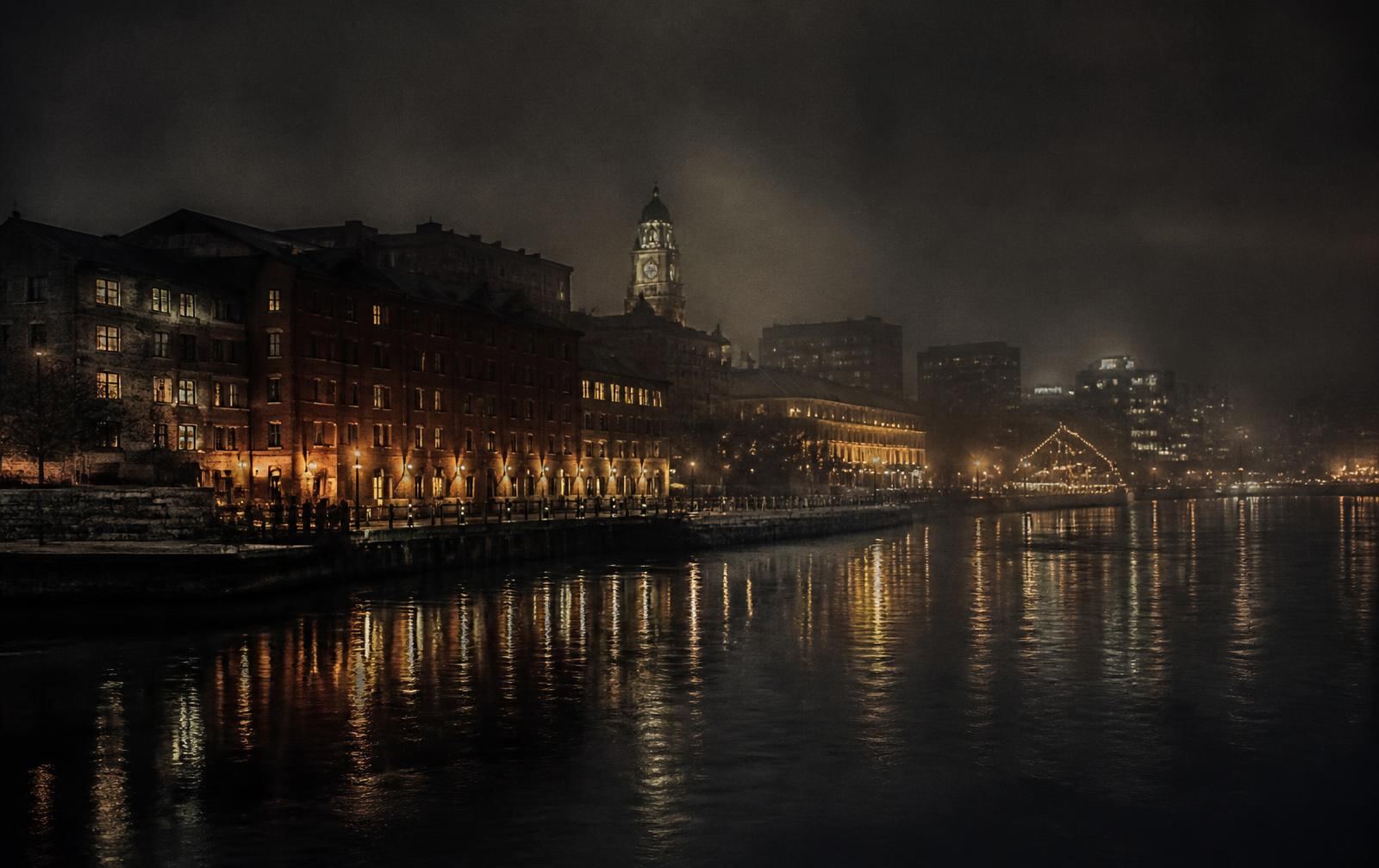 Halifax waterfront at night with warm lights reflected on dark Atlantic water and old brick buildings in mist