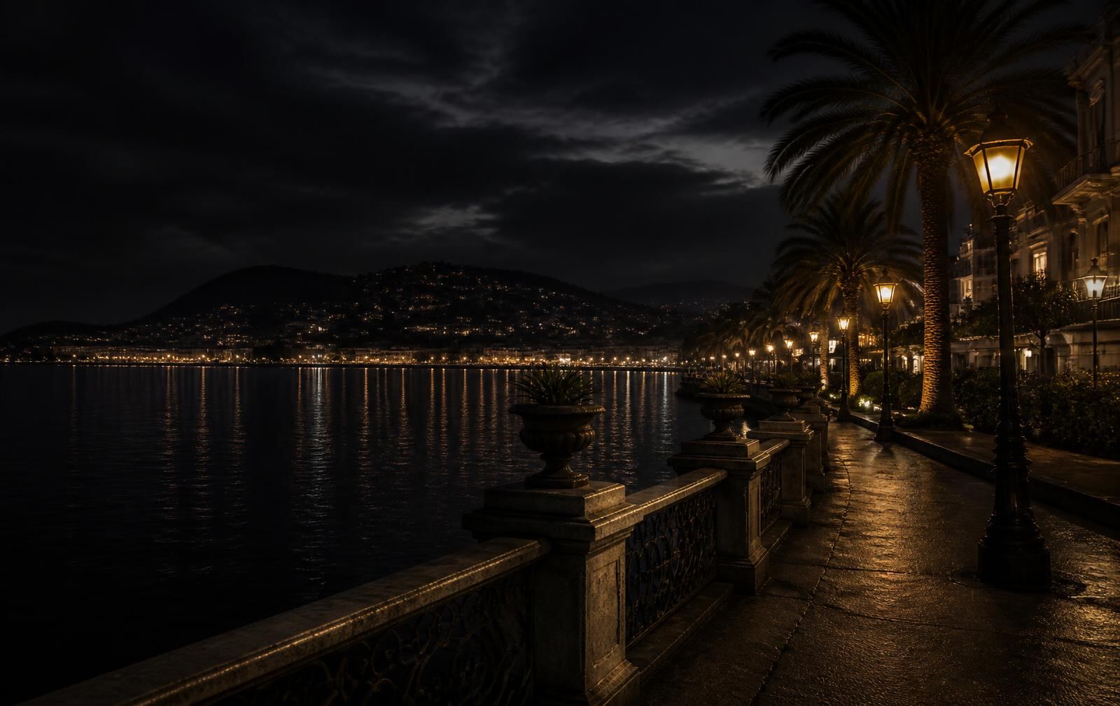 A waterfront city promenade at night beside a dark bay with palms and warm lamplight