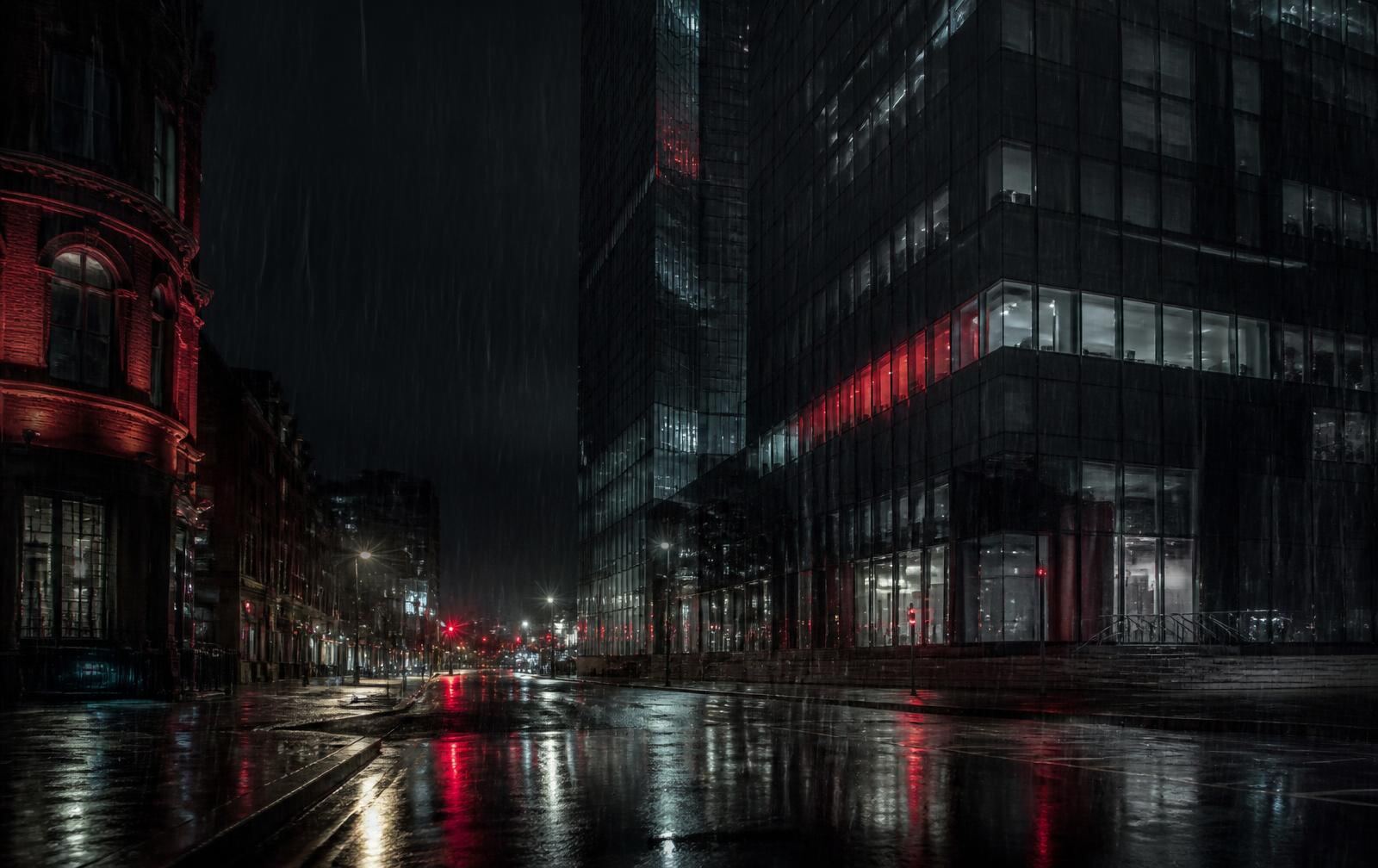 Manchester glass tower and red brick street in heavy night rain with reflections on wet tarmac