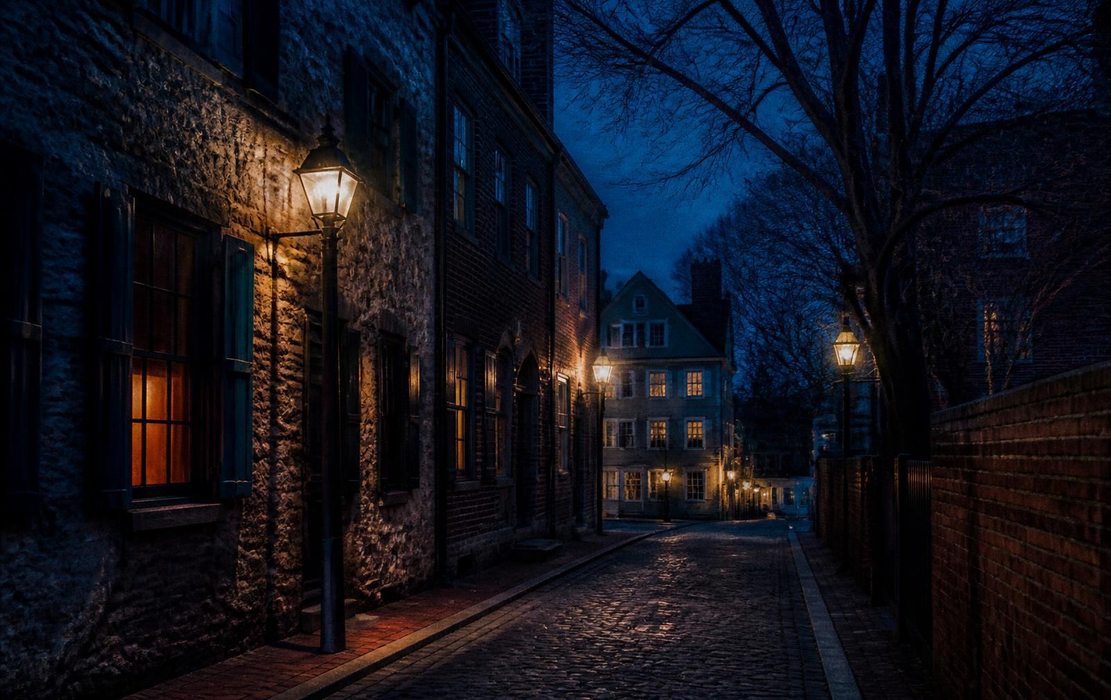 A dim, book-lined Boston room at dusk with lamplight against old brick and a rain-streaked window