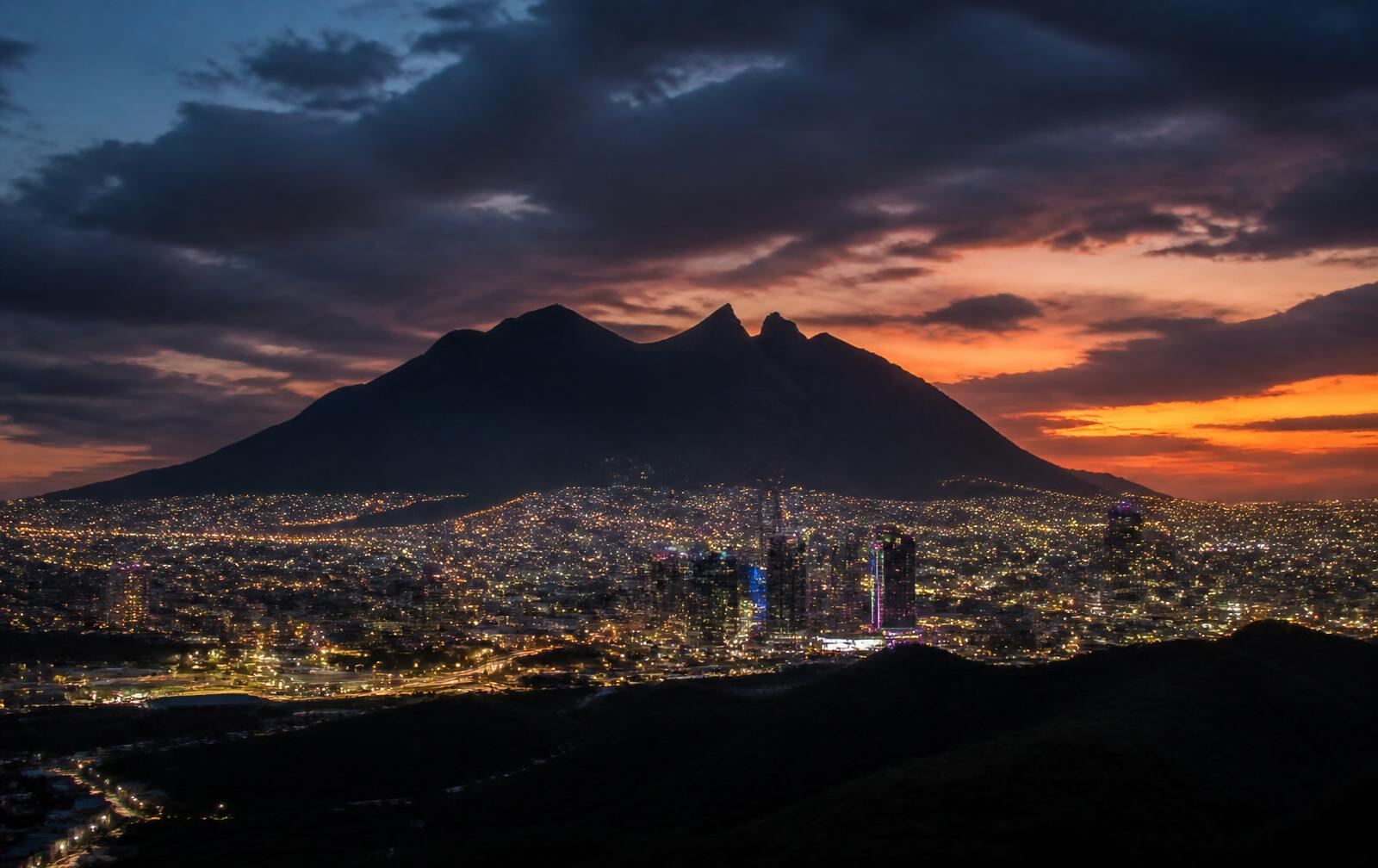 Monterrey at dusk with the saddle-shaped Cerro de la Silla silhouette above the city lights