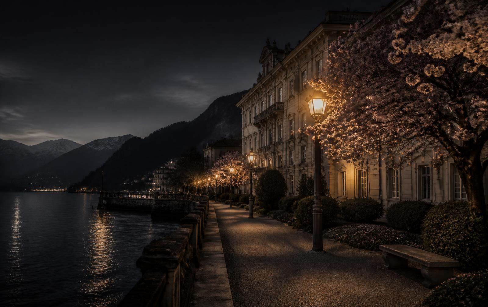A belle-epoque lakeside promenade at dusk with gold lamplight, flowering trees and dark mountain-ringed water