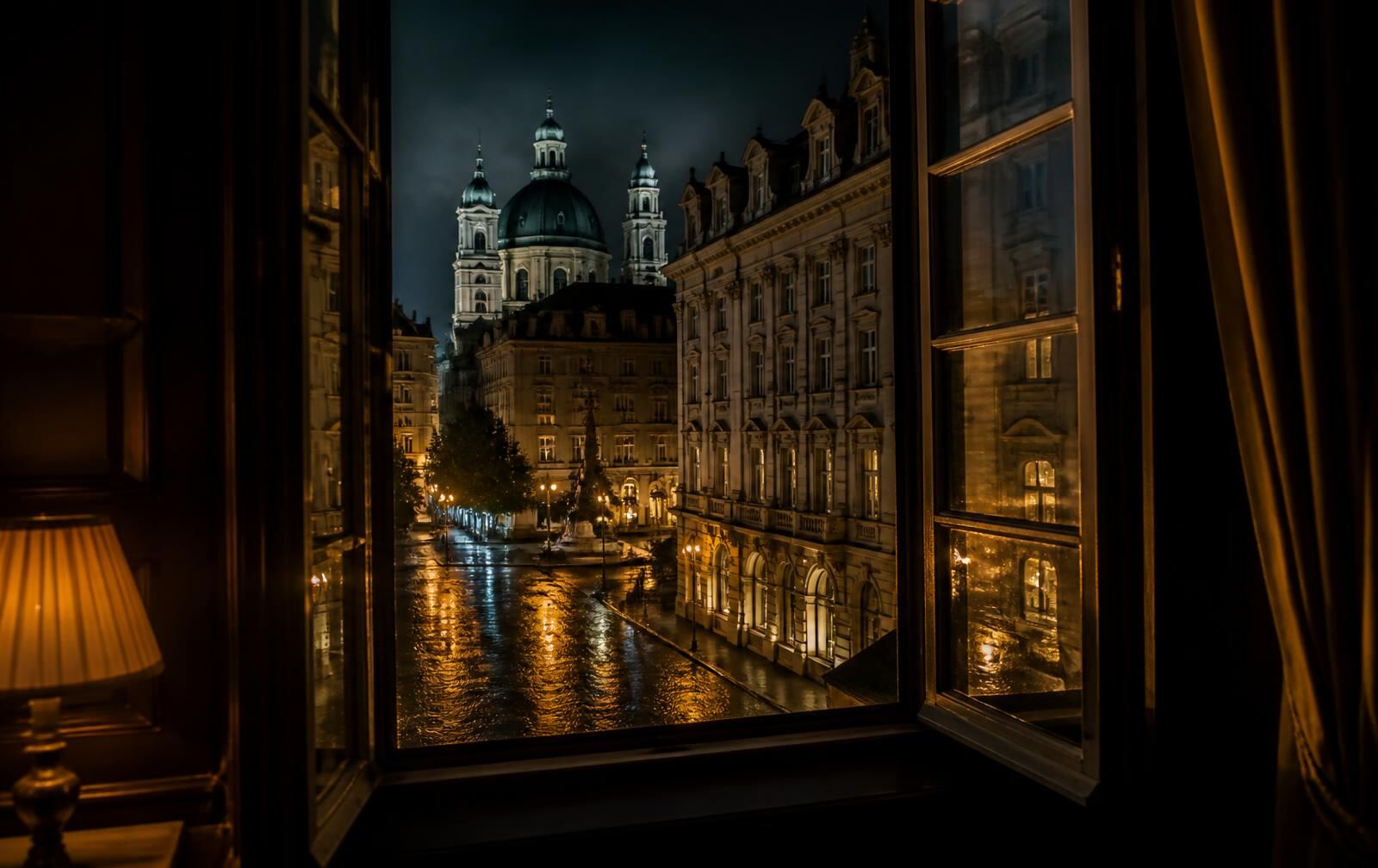 A rain-washed Munich street at night with baroque domes and warm gold lamplight, seen from a dark hotel window