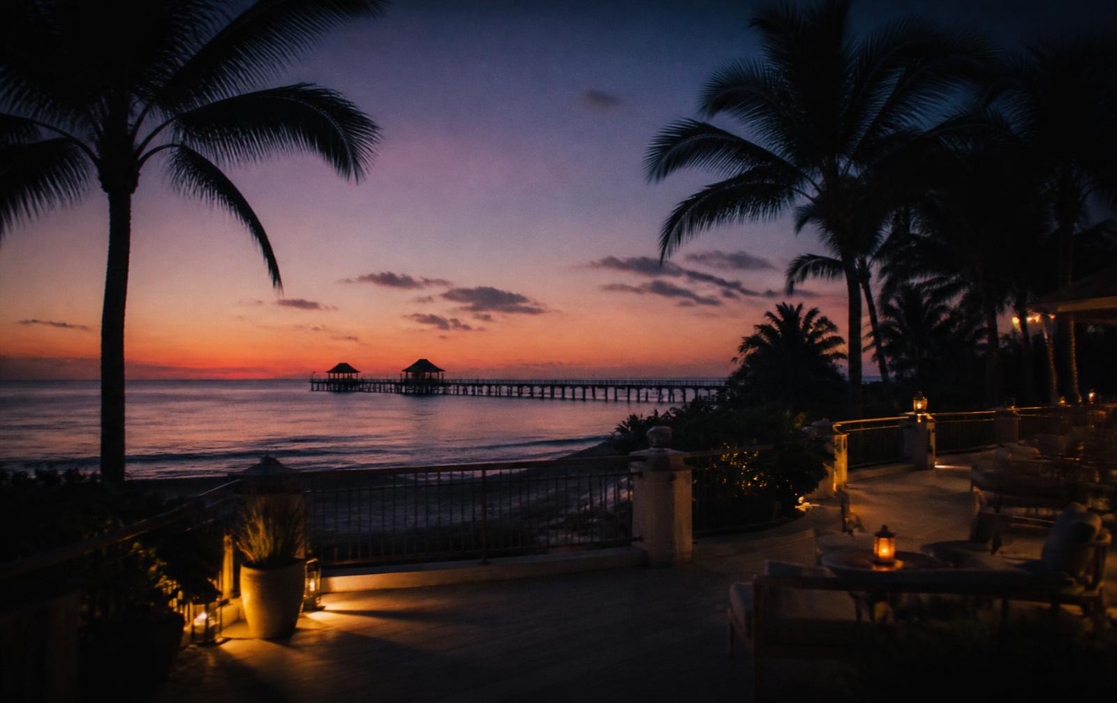 Quiet Gulf-coast hotel balcony in Naples, Florida at dusk with soft warm light