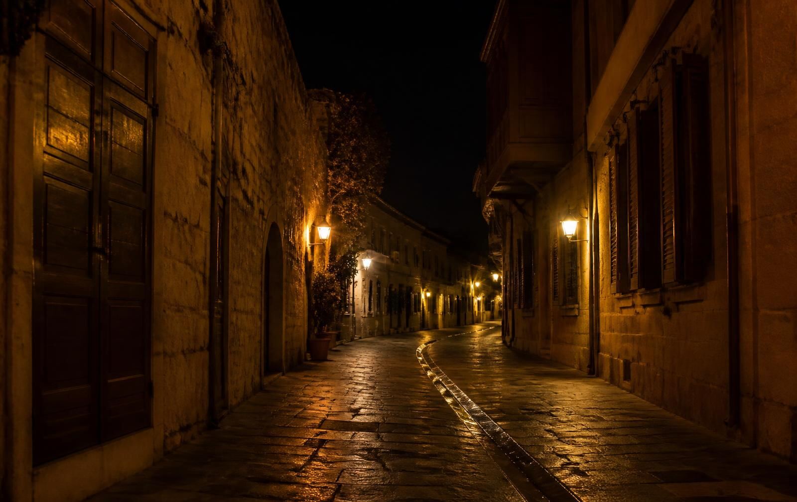 Narrow sandstone street in the old city of Nicosia at night under warm lamplight