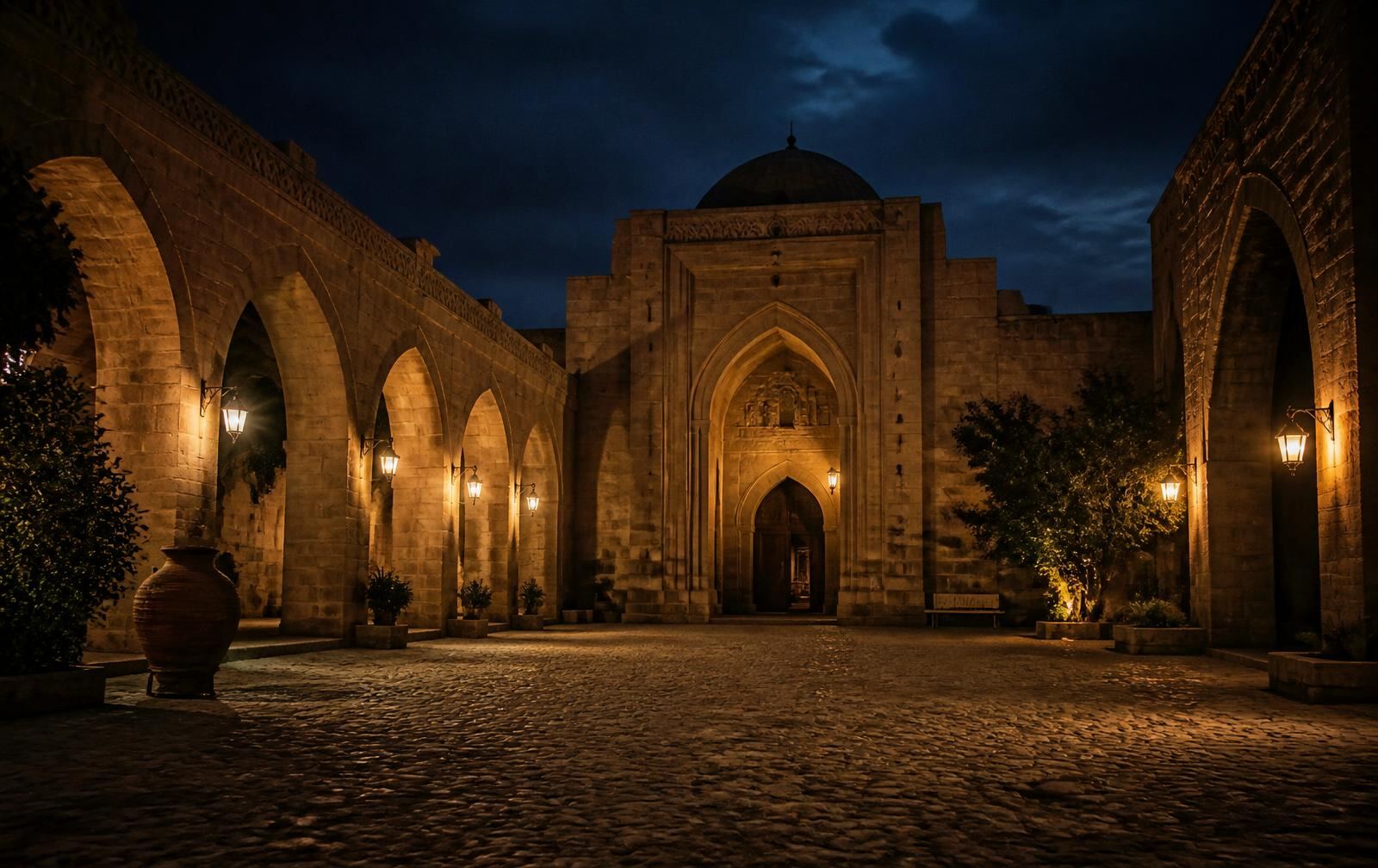 Historic stone courtyard with pointed arches lit by lanterns at night in the old city of Lefkoşa