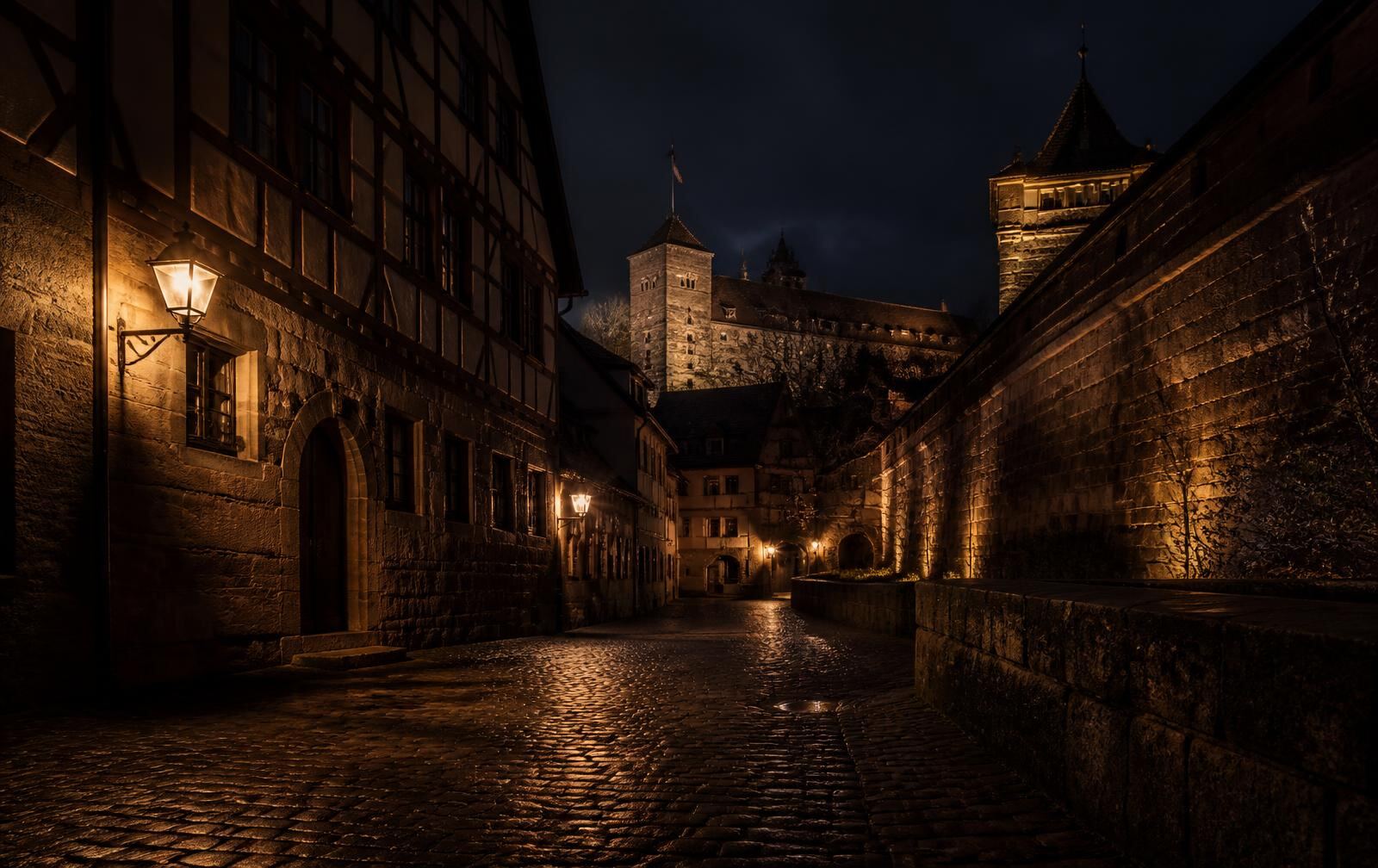 A wet cobbled Nuremberg lane at night with half-timbered houses, lantern light and the castle wall above
