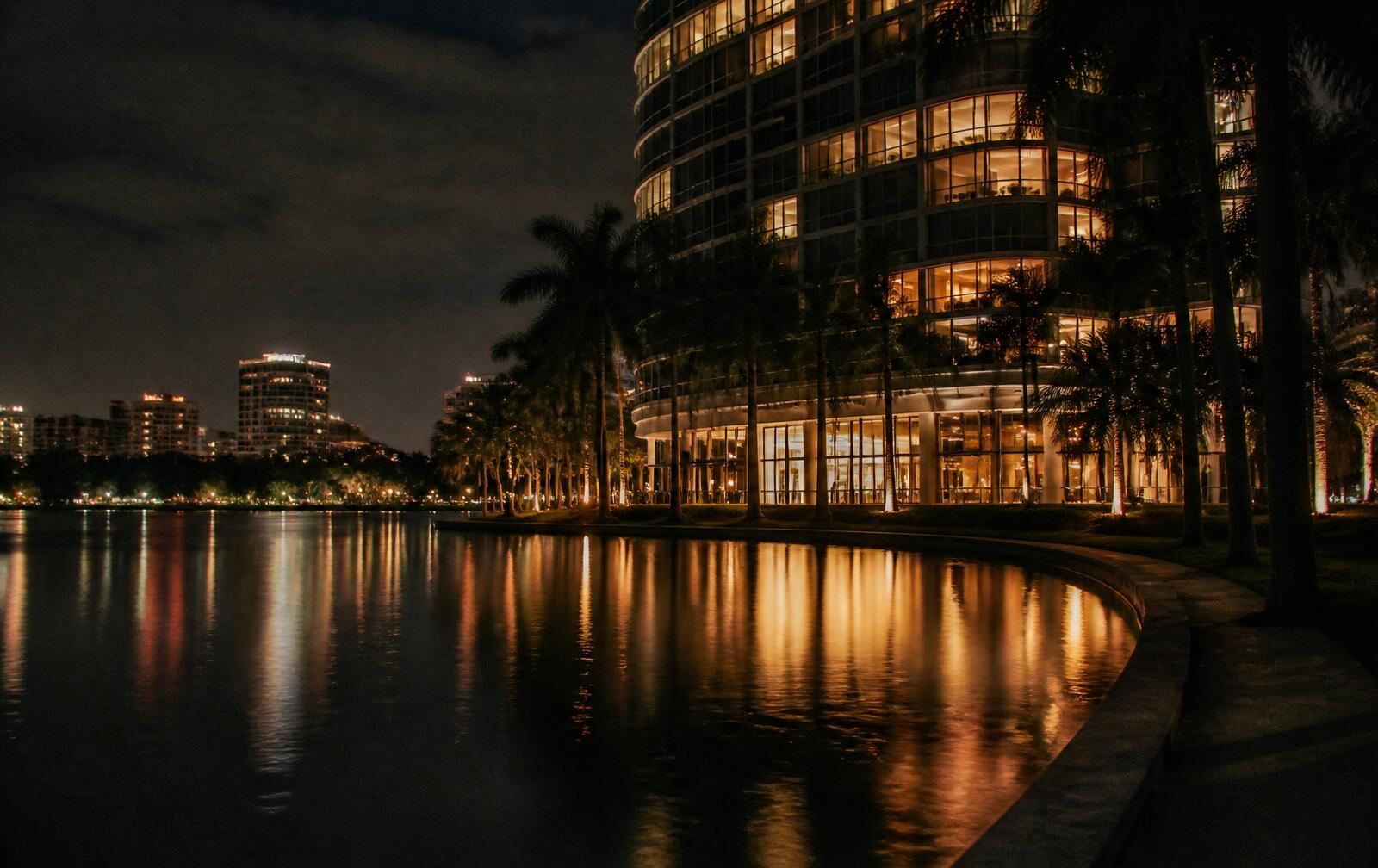 Downtown Orlando skyline reflected on a lake at dusk with soft hotel window light