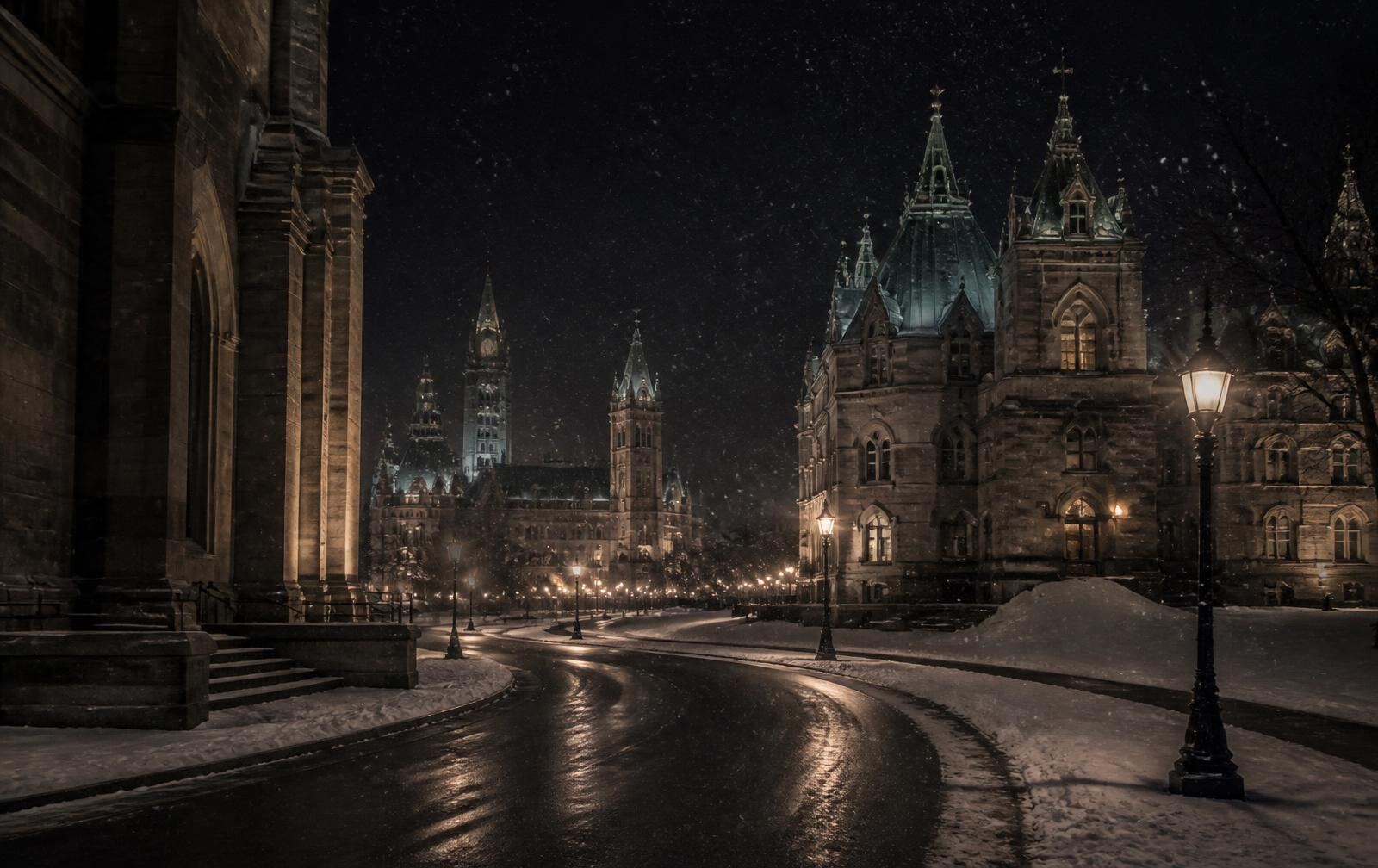 Formal Ottawa stone architecture at night in winter with snow and warm lamplight along an empty street