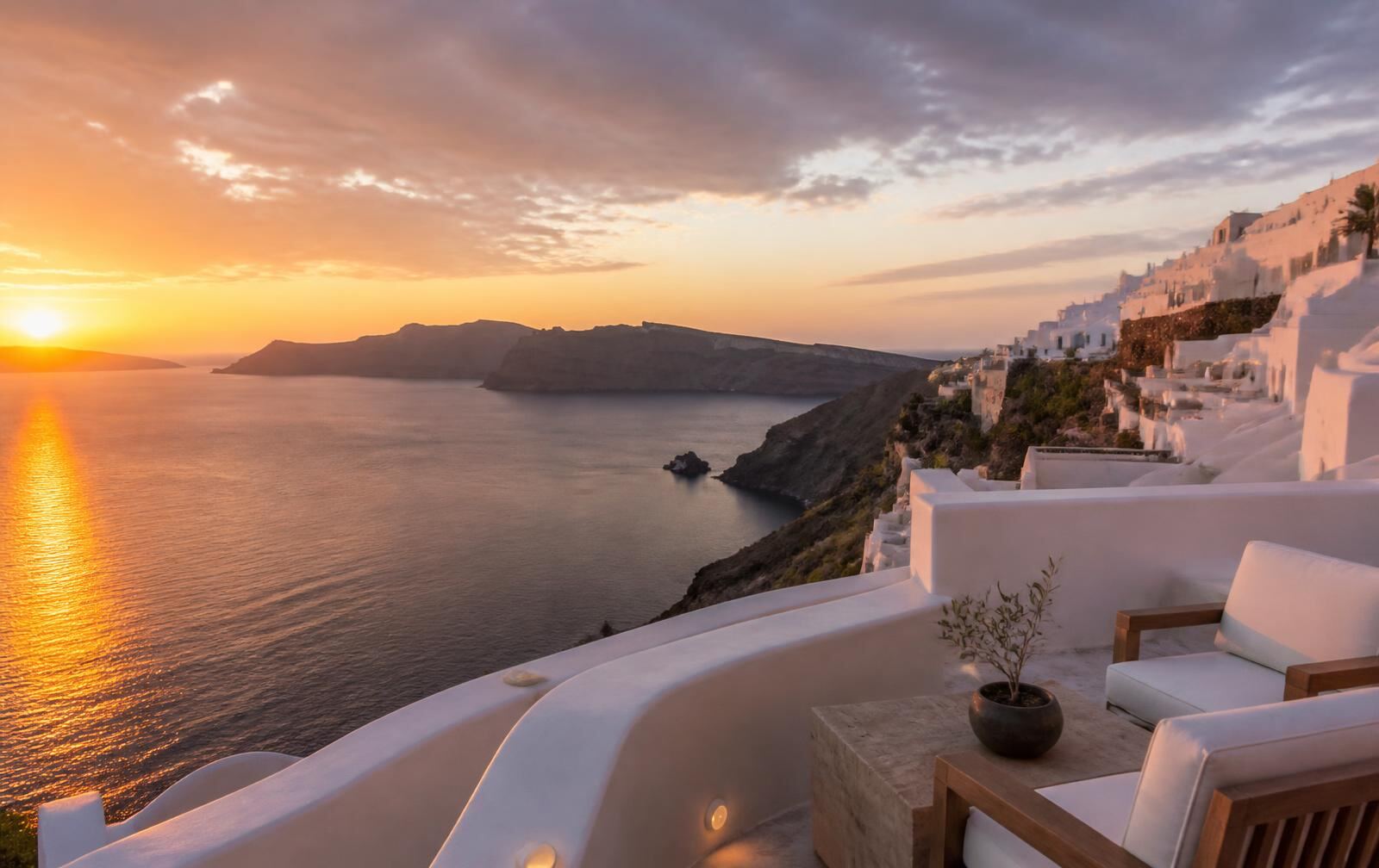 A quiet Santorini terrace overlooking the caldera during a warm sunset