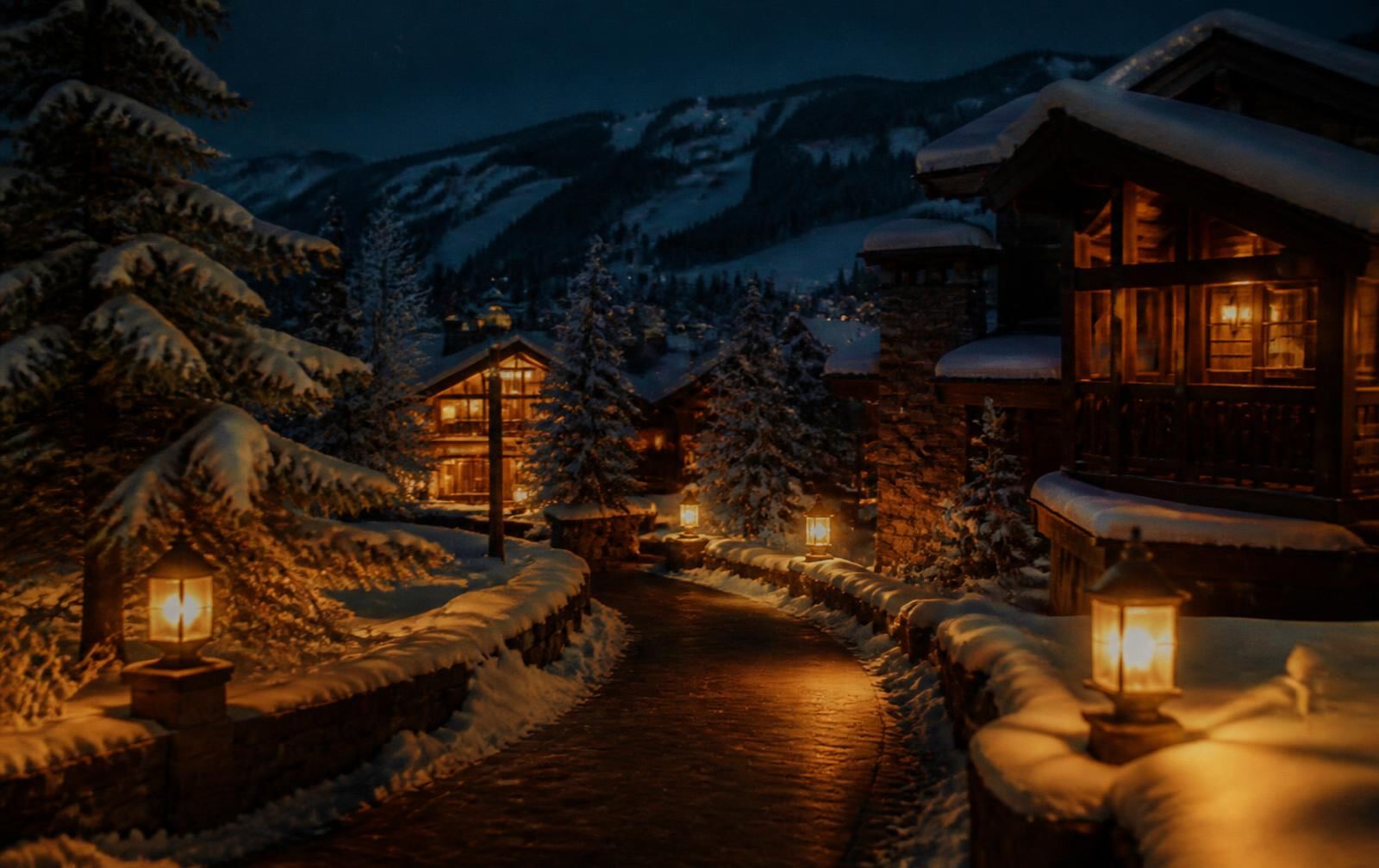 Alpine village lights glowing beneath snow-covered peaks in Vail at nightfall