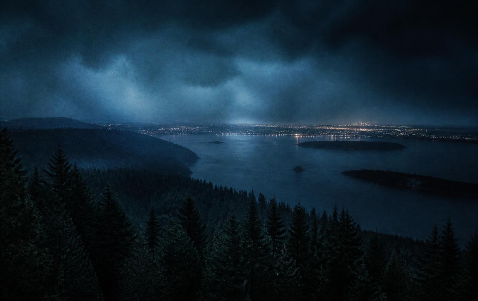 Seattle skyline blurred by rain seen through a dark window at night